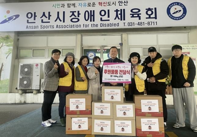 안산시장애인체육회와 자원봉사단체 '기쁨을 주는 사람들' 관계자들이 후원물품을 전달하며 기념촬영을 하고 있다.