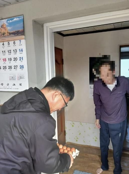 이정진 선장면장이 관내 독거 어르신 가정을 방문해 계란을 전달하고 건강 상태를 확인하고 있다.
