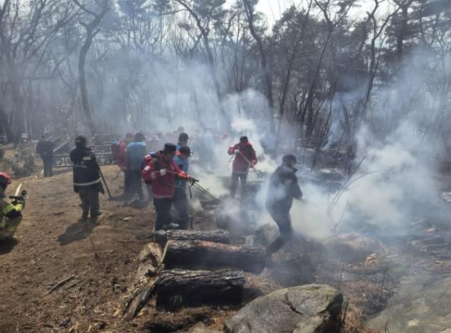 지난 12일 팔달산 화재 현장에서 잔불을 정리하는 모습